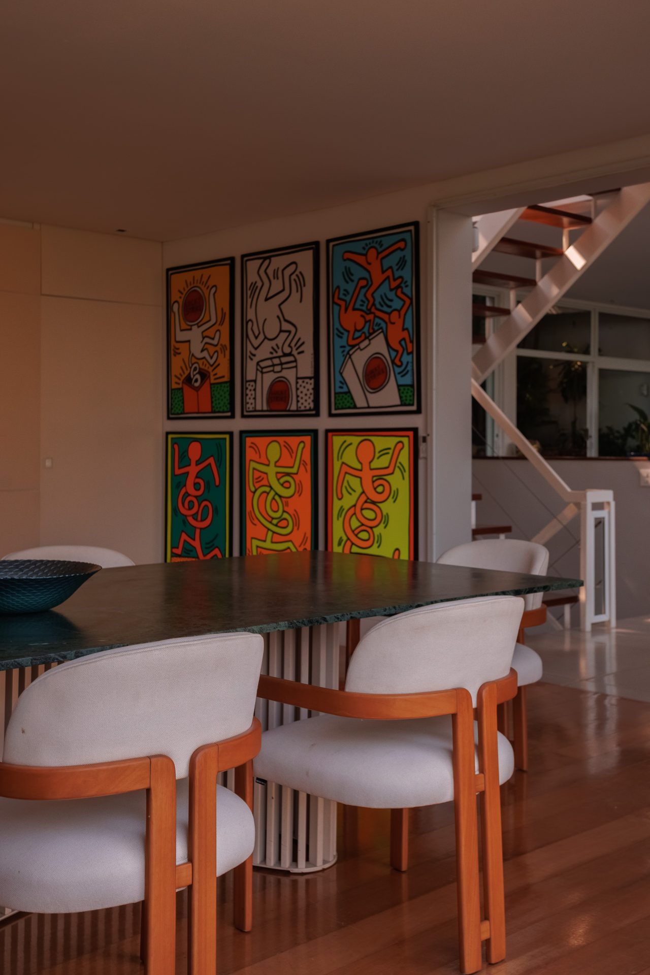Sala de jantar com seis obras originais de Keith Haring — mesa de reuniões na Villa Irvana