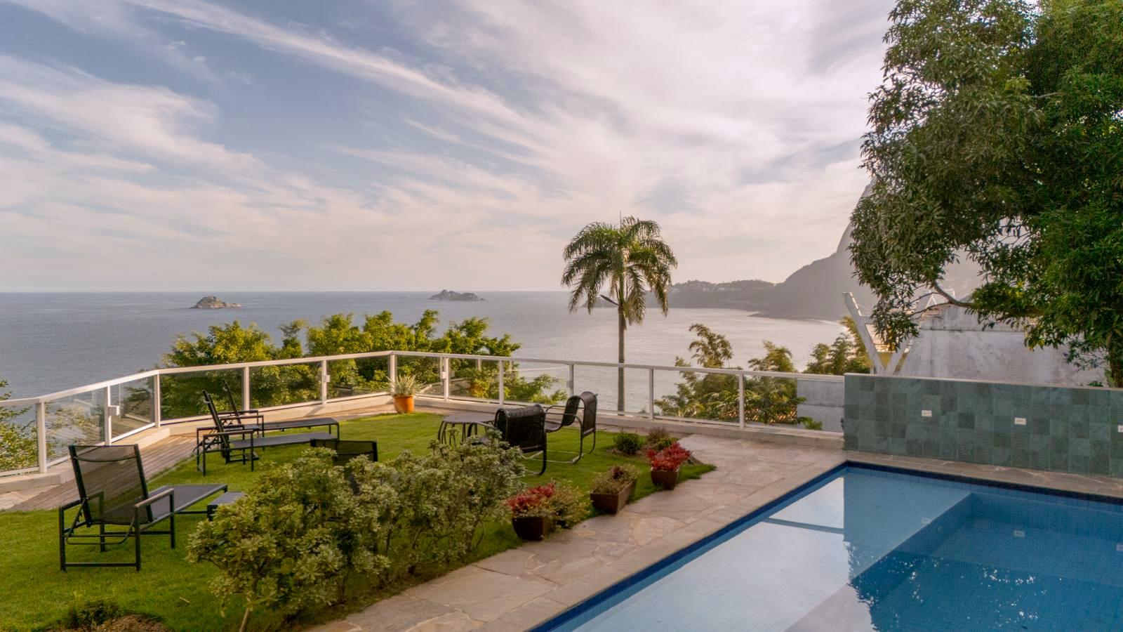 Jardim da Villa Irvana ao pôr do sol com vista para o mar