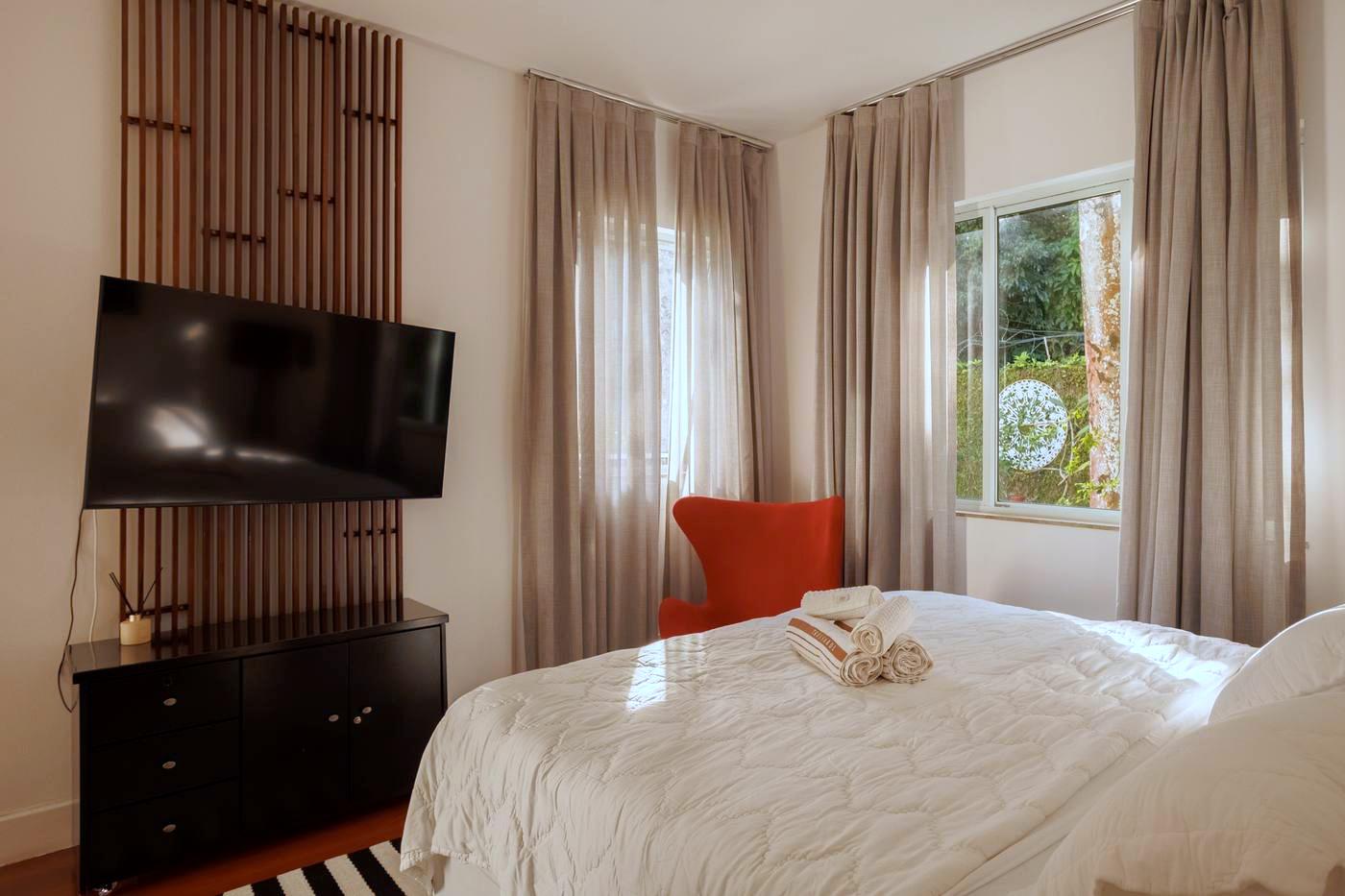Suíte com TV e poltrona de design